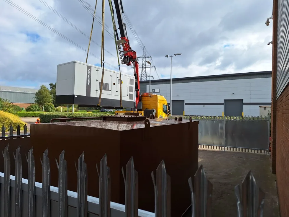 Large Himoinsa diesel generator craned into position on an industrial site