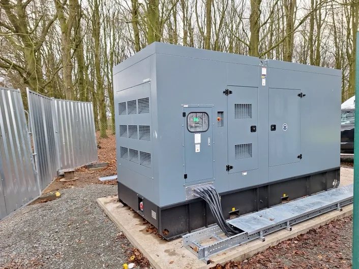 Canopied diesel generator installed on a concrete plinth with cable tray